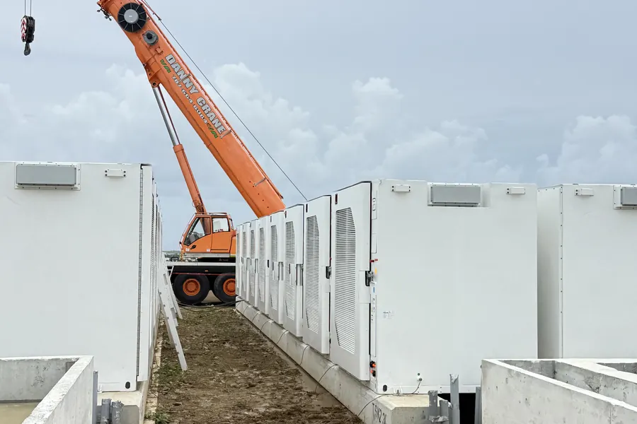 Crane setting battery enclosures during construction