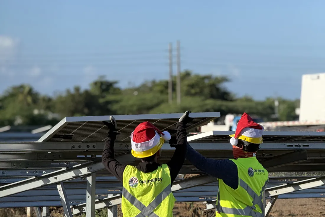 Two installers lifting a module into position
